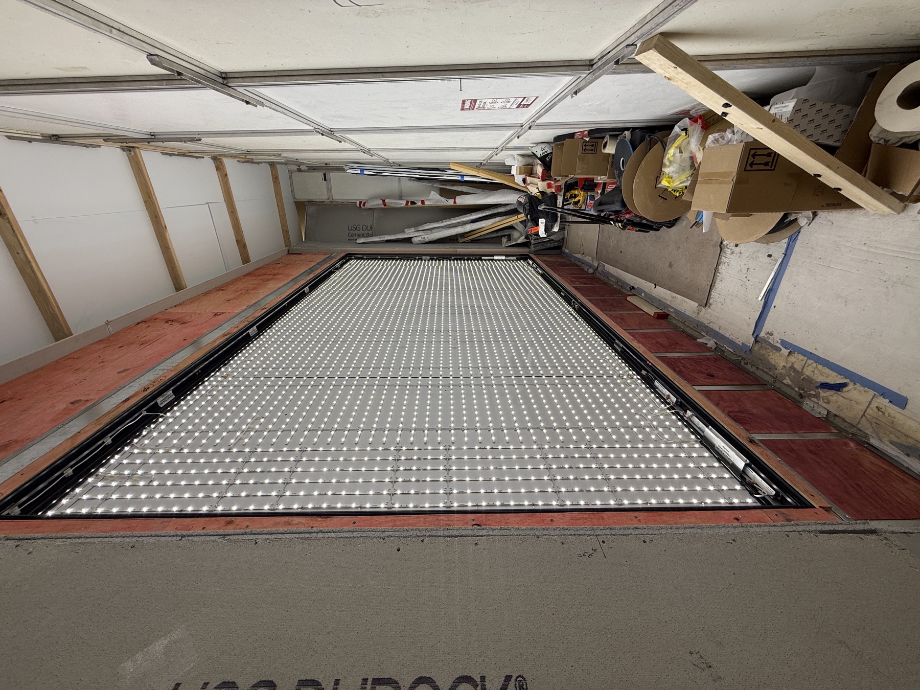 LED module grid wired inside a large lightbox cabinet during service